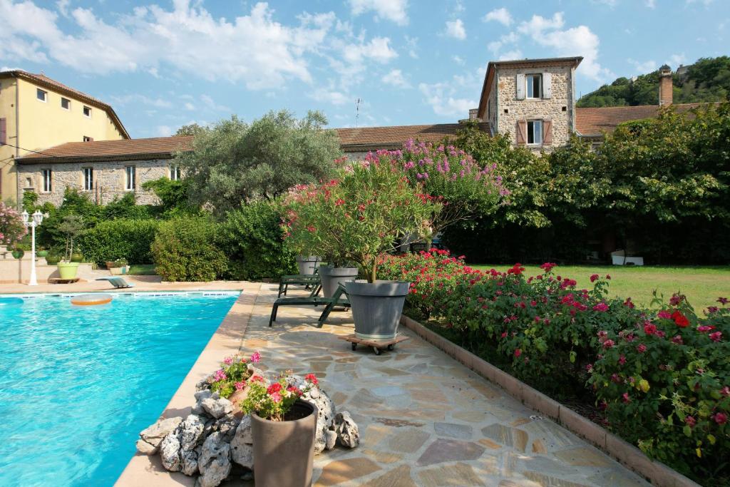 a garden with a swimming pool and flowers at Gîte "Le Tilia" aux magnolias in Aubenas
