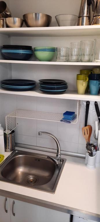 un lavandino in cucina con piatti e stoviglie di CASA HONDA10 a Granada