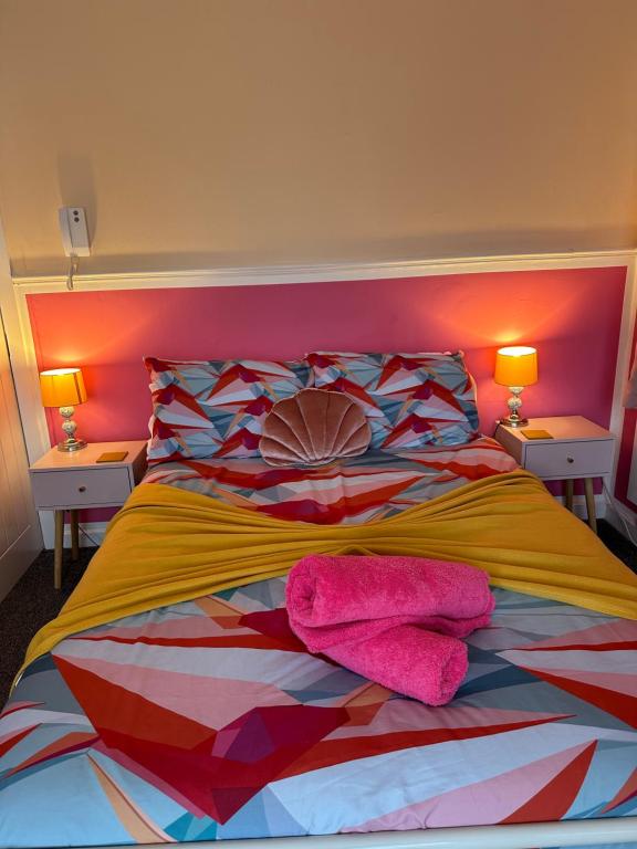 a bedroom with a colorful bed with two lamps at Blackpool Rocks Pleasure Beach in Blackpool