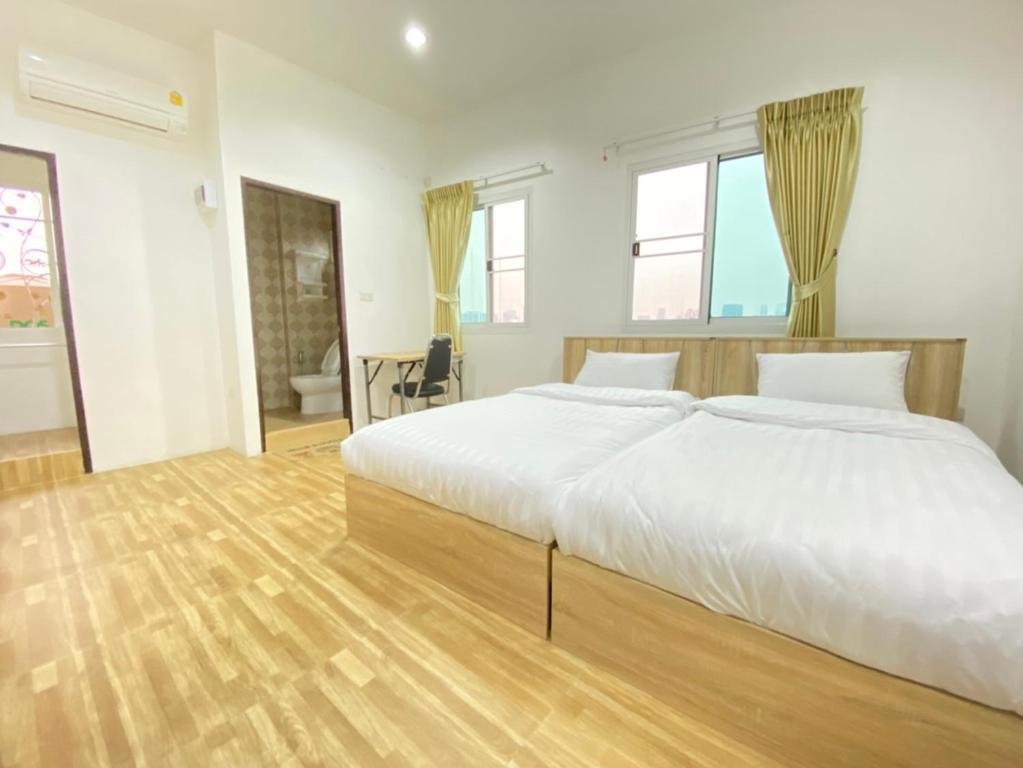 Wellness Mansion Hotel في Dusit: غرفة نوم بسرير ابيض كبير وارضية خشبية