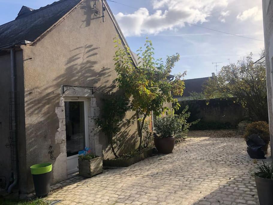 un petit bâtiment avec une porte et quelques plantes dans l'établissement maison de ville agréable La roseraie Musicale, à Mer