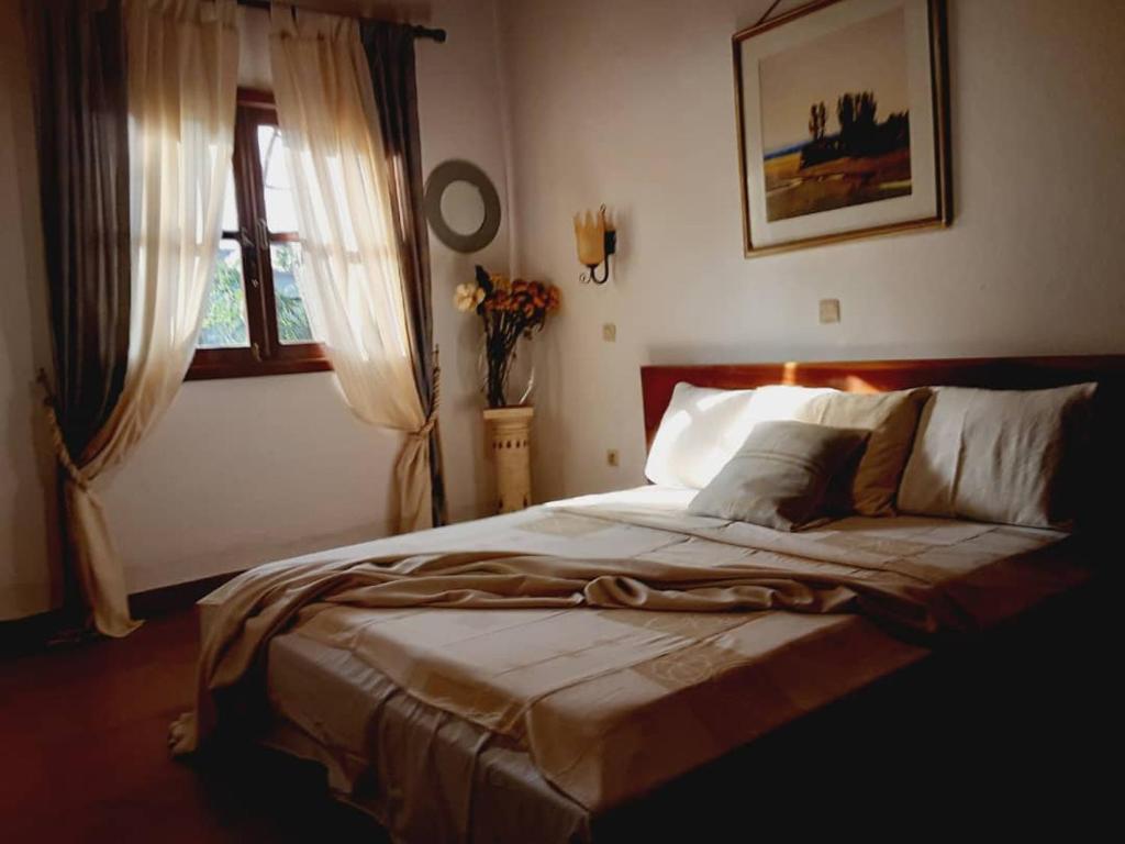 a bedroom with a large bed in front of a window at Village NDJIKESSI in Yaoundé