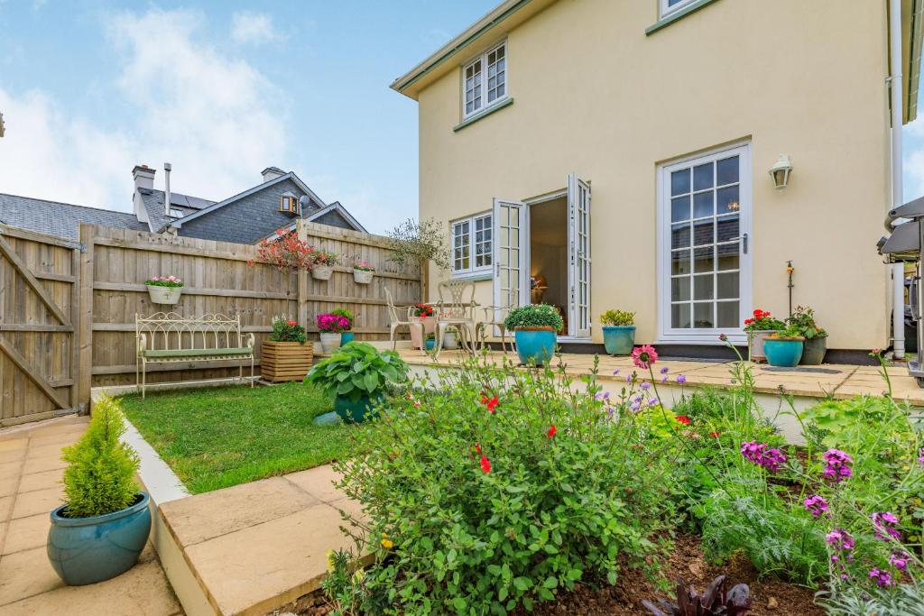 a backyard with a wooden fence and a garden at Olive Tree Cottage in Exeter