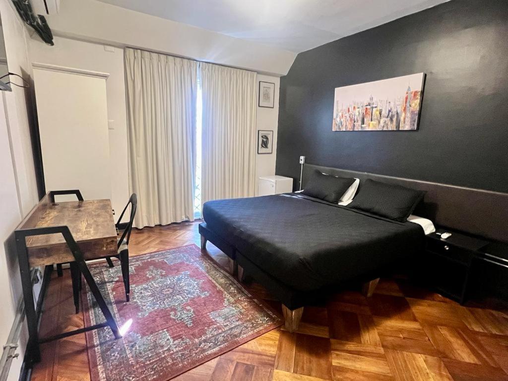 um quarto com uma cama, uma mesa e uma secretária em Hotel Boutique Tremo Bellavista Suite em Santiago