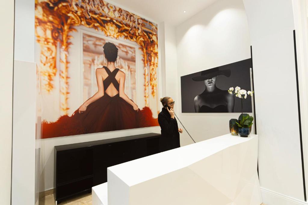 Eine Frau steht vor einem Gemälde in einem Museum. in der Unterkunft Mode Paris Aparthotel in Paris