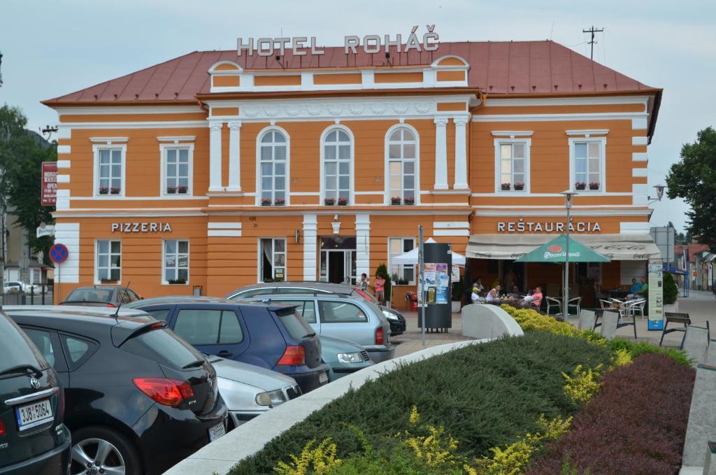 un gran edificio con coches estacionados frente a él en Hotel Roháč, en Trstená