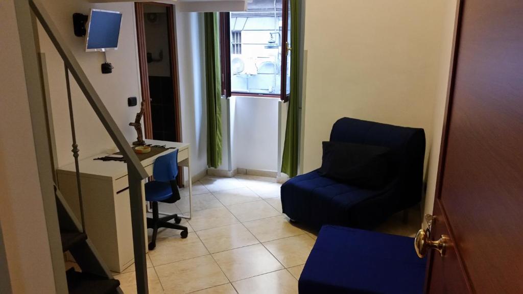 a living room with a blue chair and a desk at Residenza Il Castello in Naples