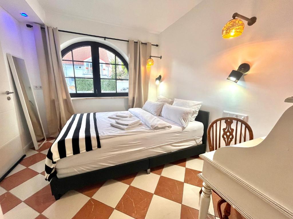 a bedroom with a bed in a room with a window at VILLA ORCHARD Frankfurt in Zeilsheim