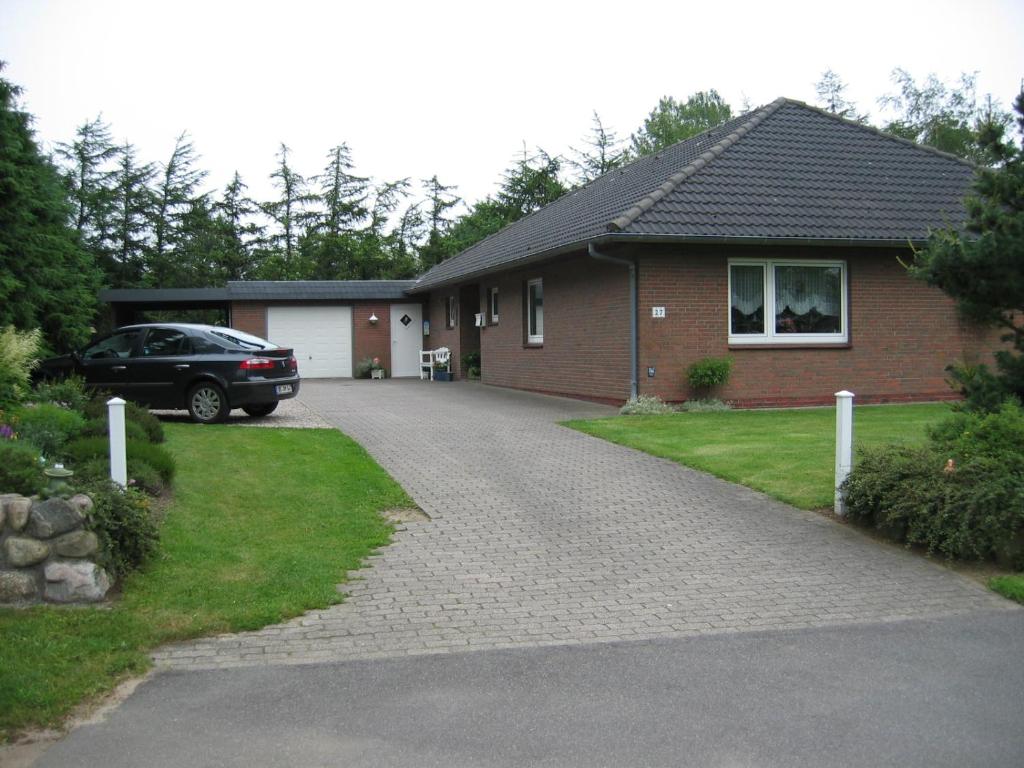 a house with a car parked next to a driveway at Haus "Sonnenschein" in Breklum