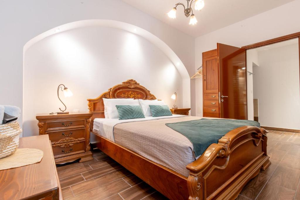 una camera con un grande letto con testiera in legno di Mascot Memories a Città di Rodi