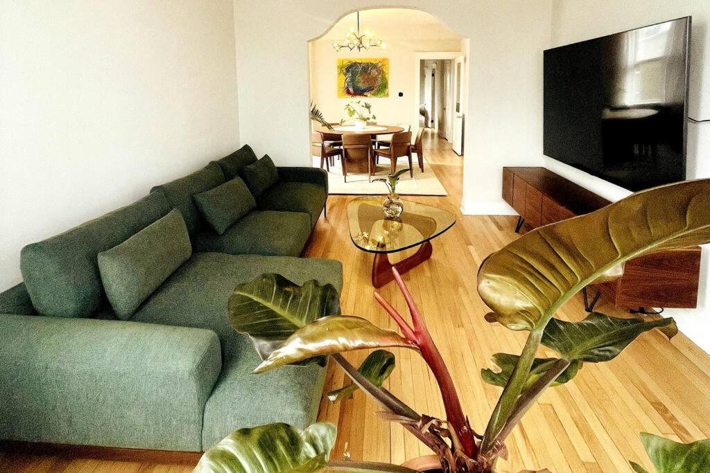 sala de estar con sofá verde y mesa en Stunning 4BD/2BA Getaway Chicago, en Chicago