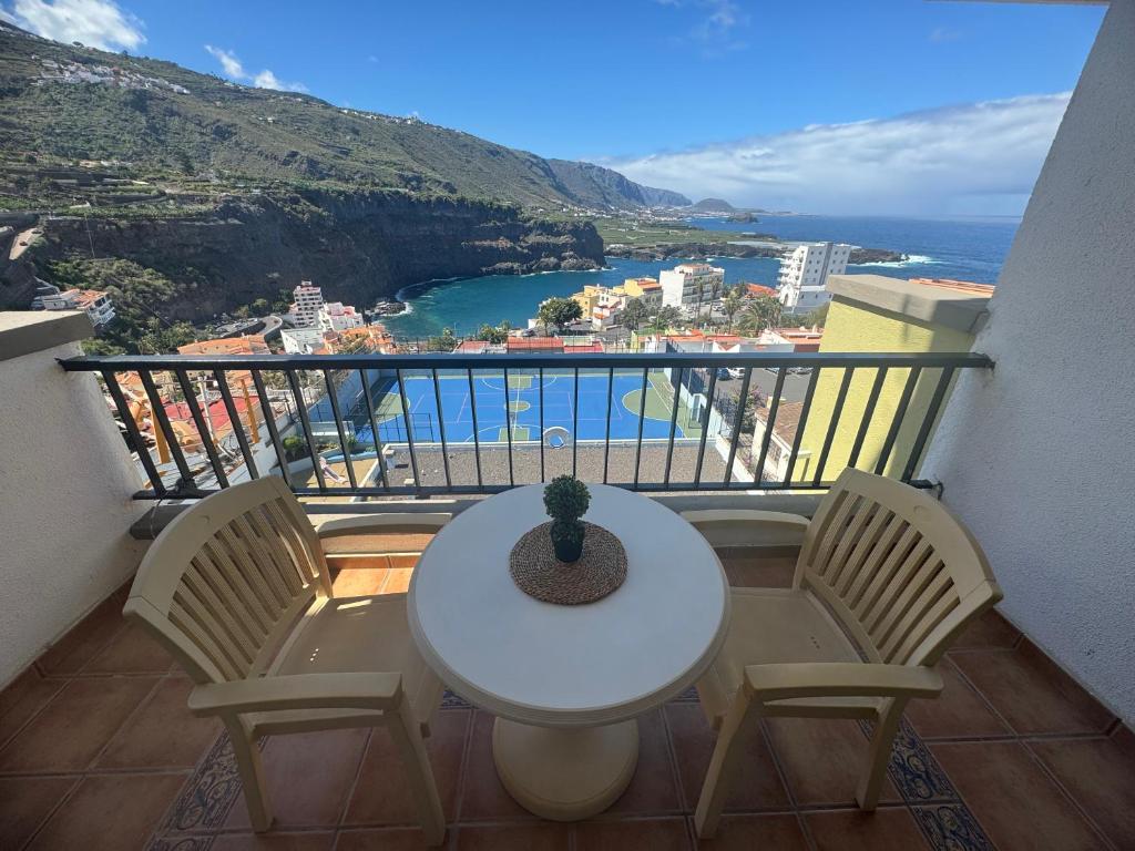 una mesa y sillas en un balcón con vistas al océano en Balcón del Mar, en Icod de los Vinos