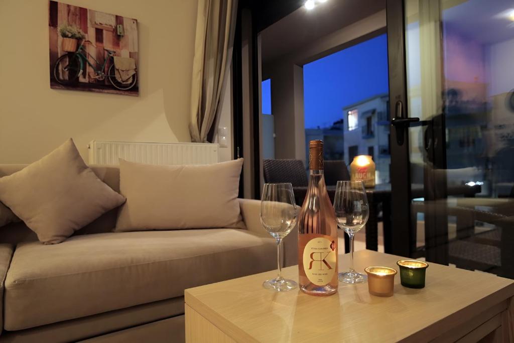 a living room with a couch and two wine glasses on a table at Onyx City Center Apartment in Heraklio