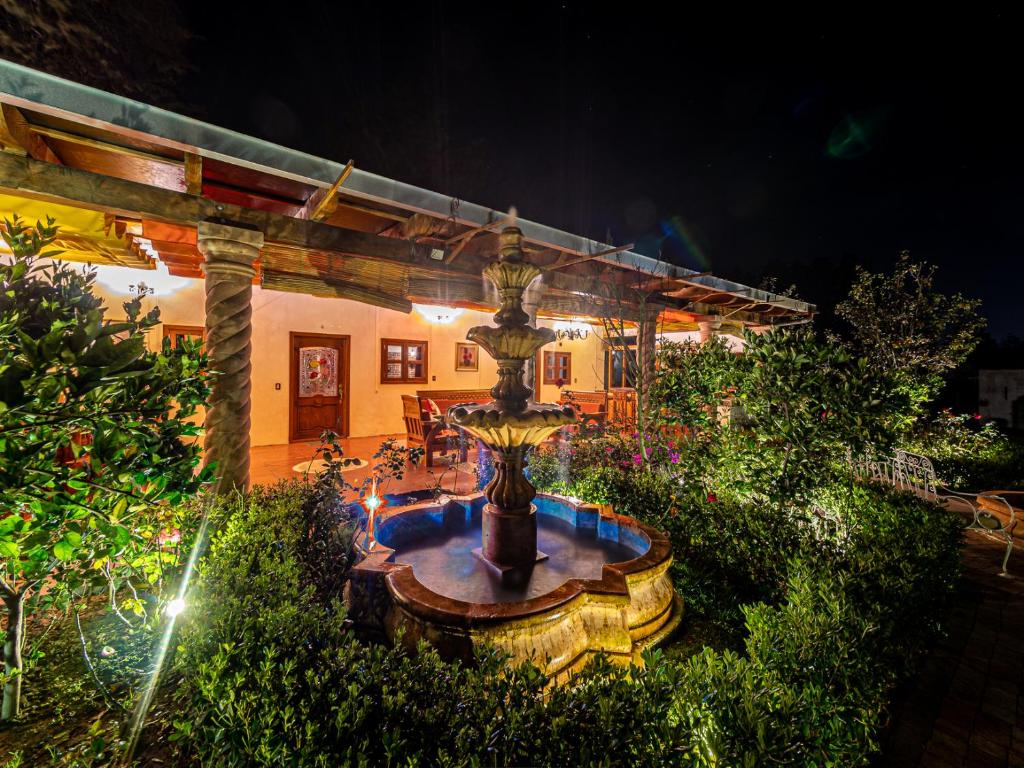 una fuente en medio de un jardín por la noche en Dos Cabañas, Popocatépetl e Iztlaccíhuatl, en Atlautla