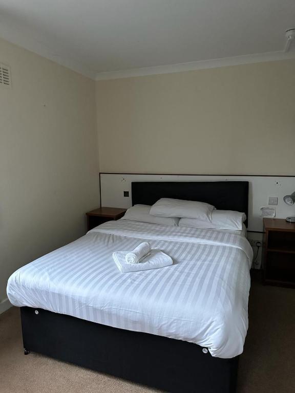 a bed with a white towel on top of it at The Kinross Salutation Hotel in Kinross