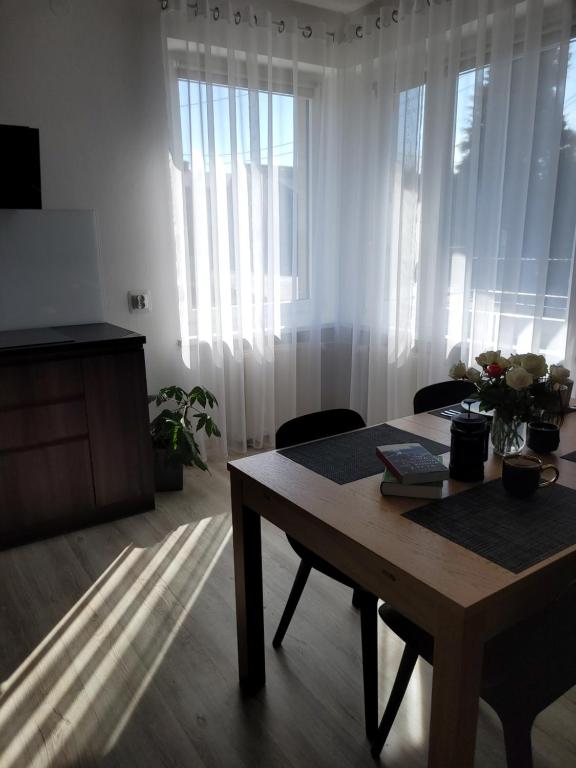 a living room with a table and some curtains at Apartament BESKIDLOVE in Węgierska Górka