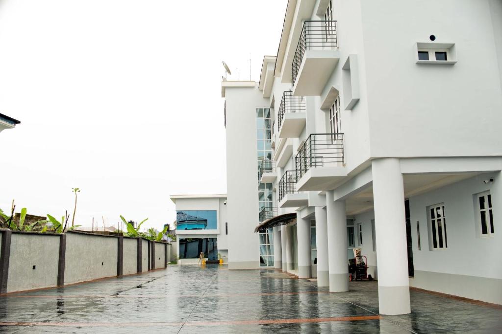 an empty street in front of a white building at 1401 Luxury Apartment in Uyo