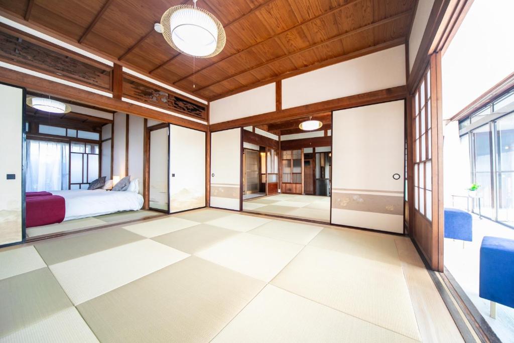 a bedroom with a bed and large windows at Kominka Besso - Vacation STAY 15819 in Kuwana