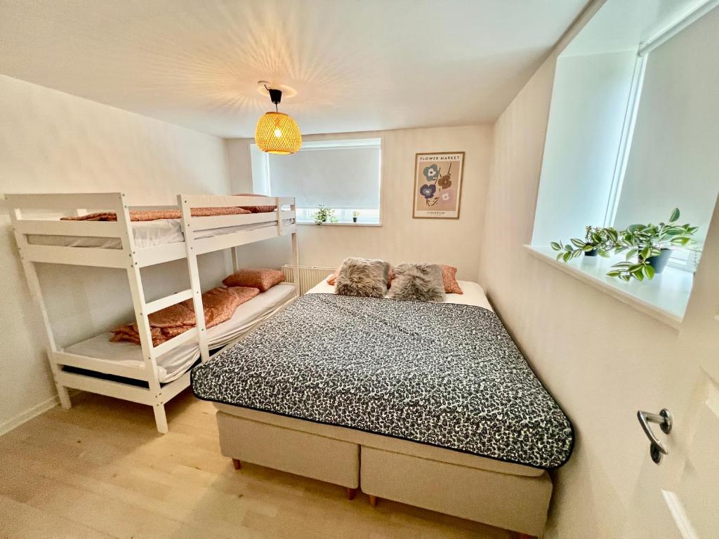 een slaapkamer met een stapelbed en een ladder bij 5 minute walk to LEGO House - 50m2 apartment with garden / A unit in Billund