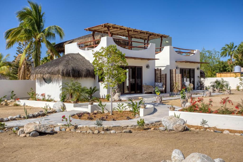 a large white house with a grass roof at Mantra Baja, Boutique Hotel in Los Barriles