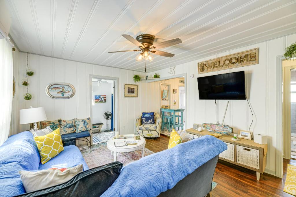 a living room with blue furniture and a ceiling fan at Cozy Texas Cottage Less Than 2 Mi to Rockport Beach! in Rockport
