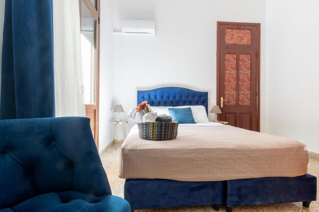 ein Schlafzimmer mit einem blauen Bett und einem blauen Stuhl in der Unterkunft mascot traditional guest house in Rhodos (Stadt)