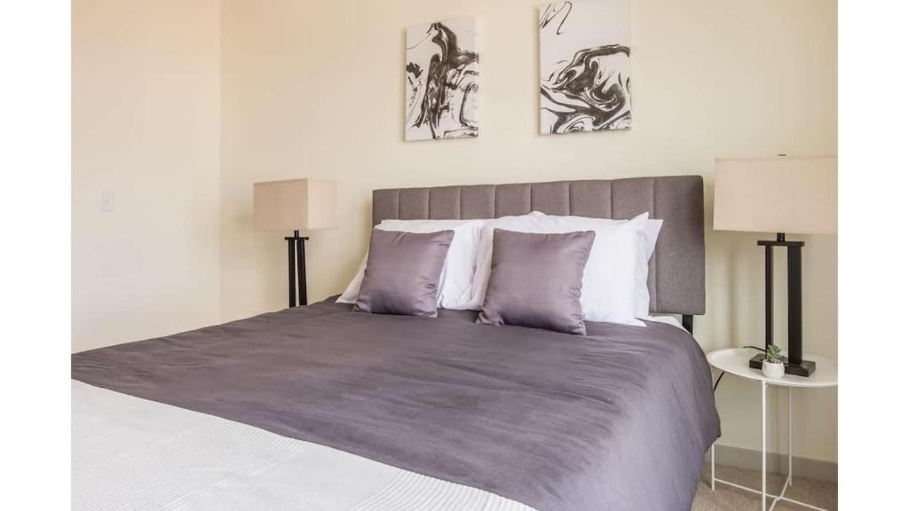 a bedroom with a large bed with purple sheets and pillows at Stunning Nulu 1BR CozySuites 04 in Louisville
