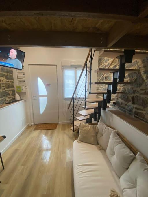 un salon avec un canapé blanc et une télévision dans l'établissement Studio charmant et cosy, à Saint-Brieuc