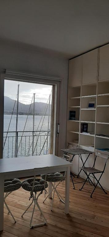 a room with a table and chairs and a large window at Monolocale La Darsena in Portoferraio