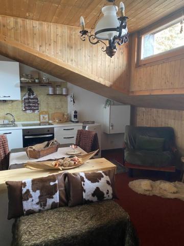 a living room with a couch and a table and a kitchen at Monolocale Condominio Valleverde Fronte Piste in Sestriere