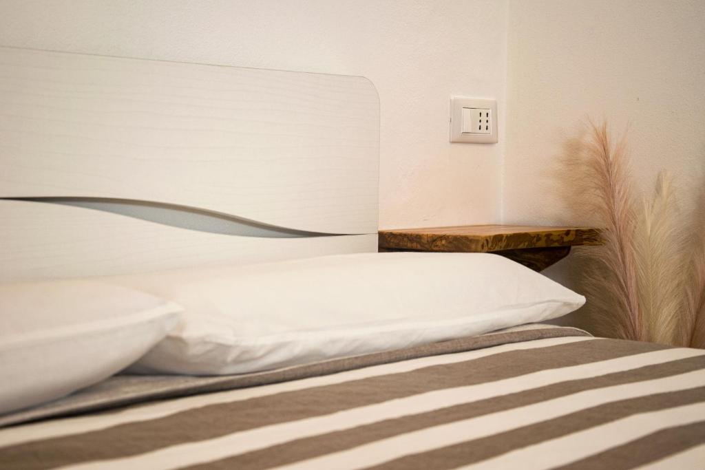Villa Essenza - Rooms and Breakfast في ألبينغا: غرفة نوم بسرير ومفتاح للوضوء