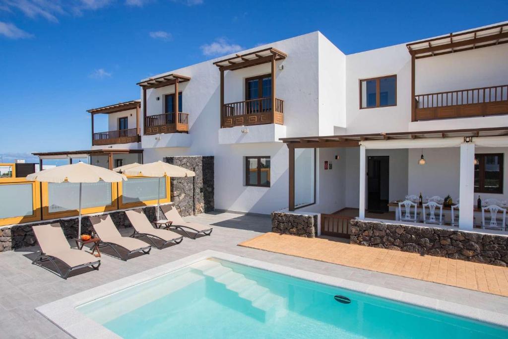 eine Villa mit Swimmingpool und ein Haus in der Unterkunft Villa Barrilla - La Vegueta Villas in Tinajo