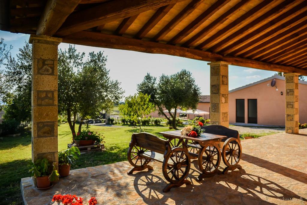 um pátio com uma mesa e uma carruagem puxada por cavalos em Agriturismo Airone em Pitigliano