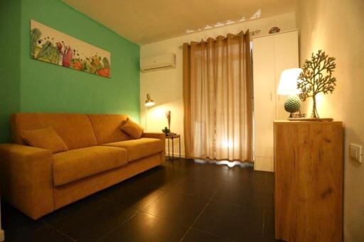 un soggiorno con divano e parete verde di Casa Nica a Palermo
