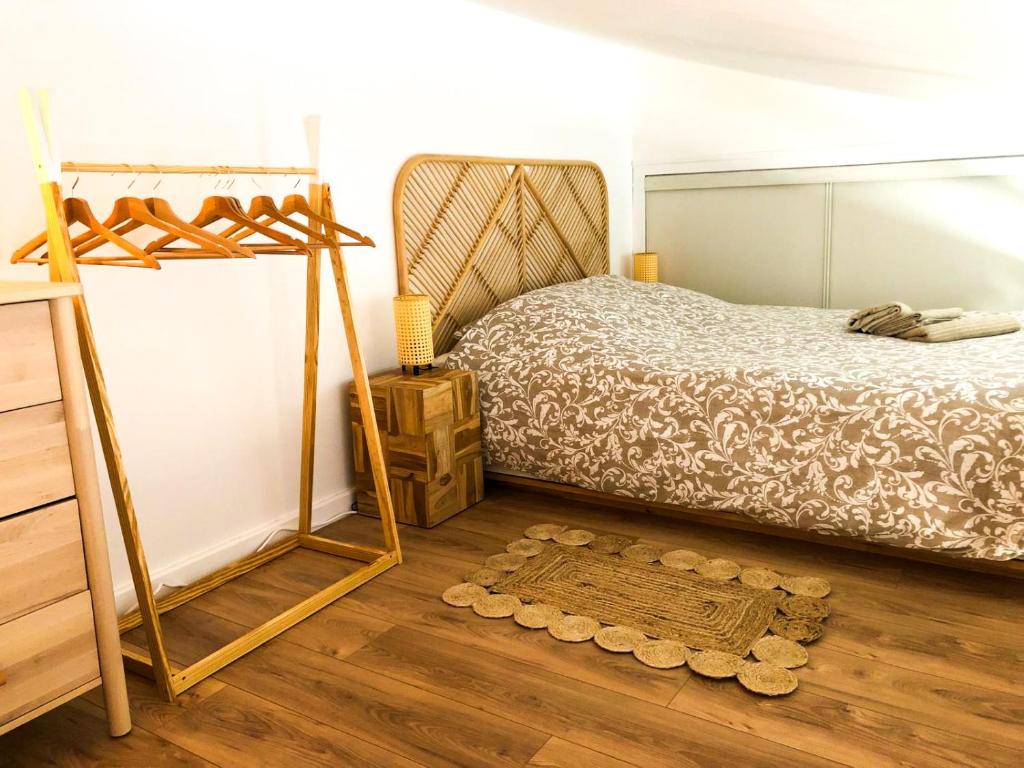 1 dormitorio con 1 cama y suelo de madera en A 150m du port, Le Baia, tout à pied, en Saint-Martin-de-Ré