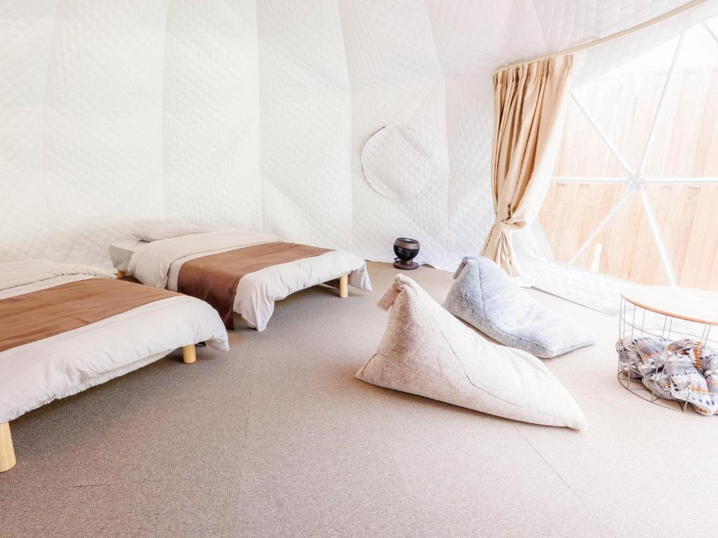 広島市にあるRiverside Glamping Kamiseno - Vacation STAY 92767vの白い部屋で、ベッド2台、窓が備わります。