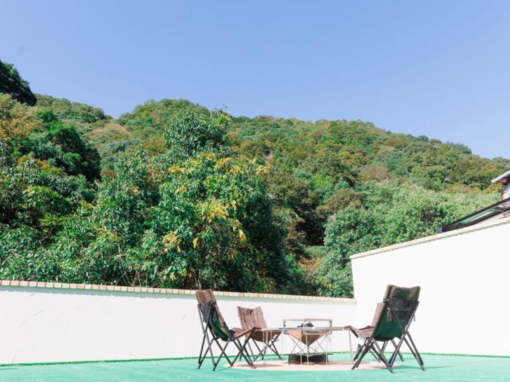 Riverside Glamping Kamiseno - Vacation STAY 92770v في هيروشيما: كرسيين وطاولة على الفناء