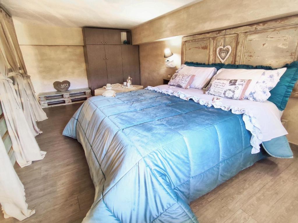 1 dormitorio con 1 cama grande y edredón azul en Home Shabby, en Porto Empedocle