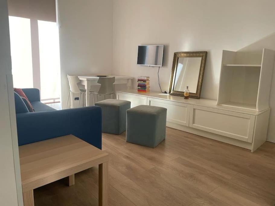 sala de estar con sofá azul y espejo en Casa “V” en San Remo