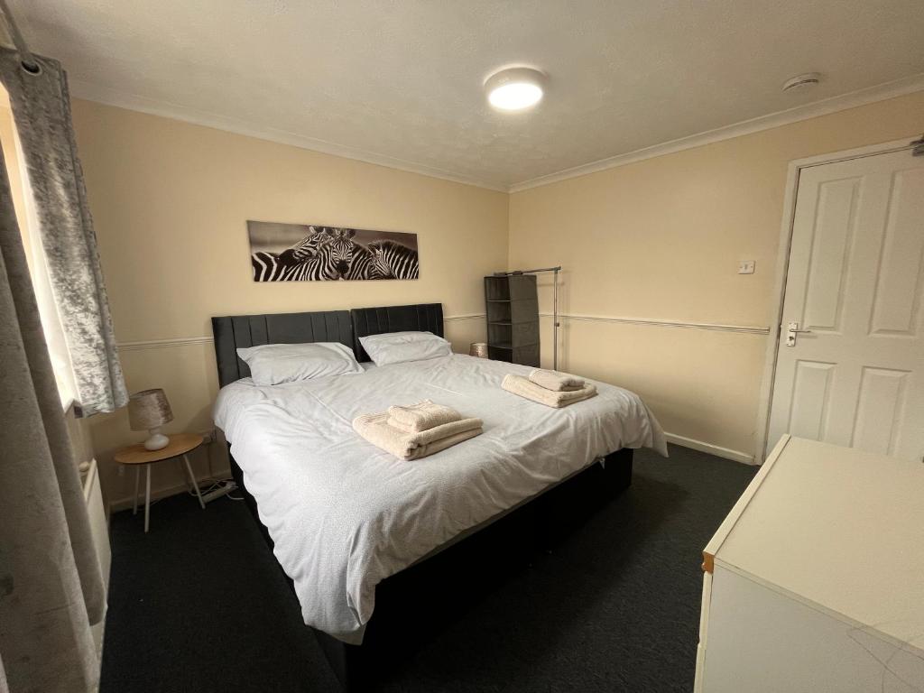 a bedroom with a bed with two towels on it at Cosy 2 bedroomed semi detached house in Brettell Lane