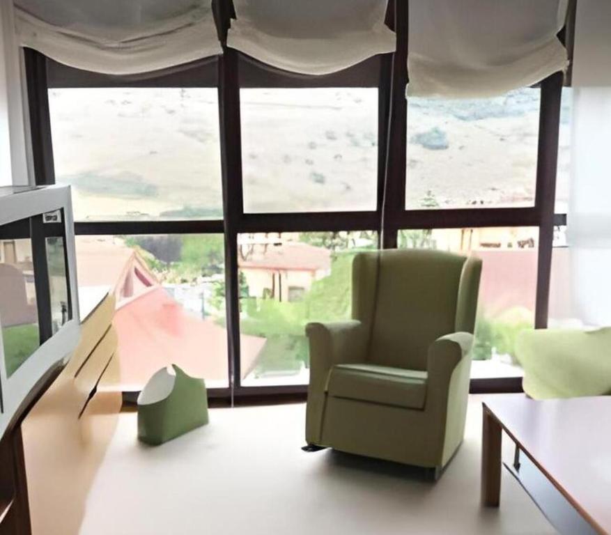 un soggiorno con sedia e una grande finestra di Balcón de Ezcaray MTB terraza y montaña a Zorraquín