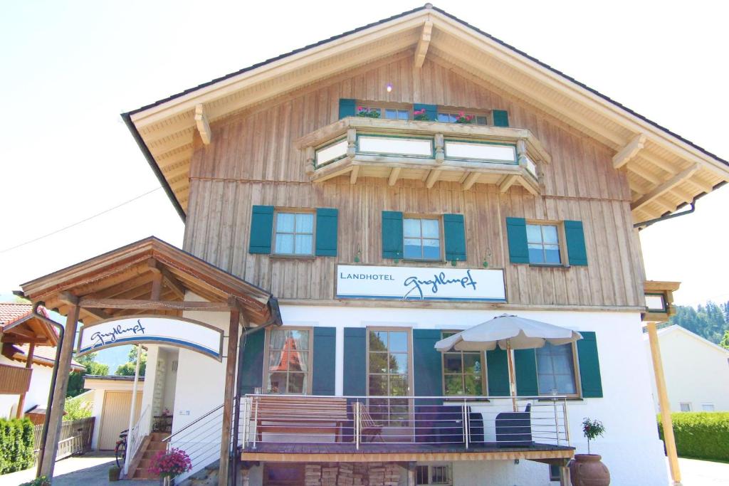 ein Holzhaus mit einem Gameradach in der Unterkunft Landhotel Guglhupf in Schwangau
