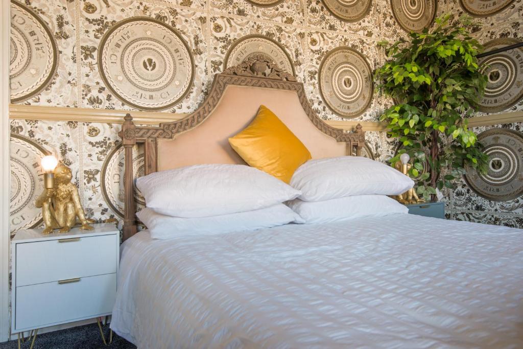 - une chambre avec un lit blanc et un oreiller jaune dans l'établissement Charming 1-Bed House in London, à Londres