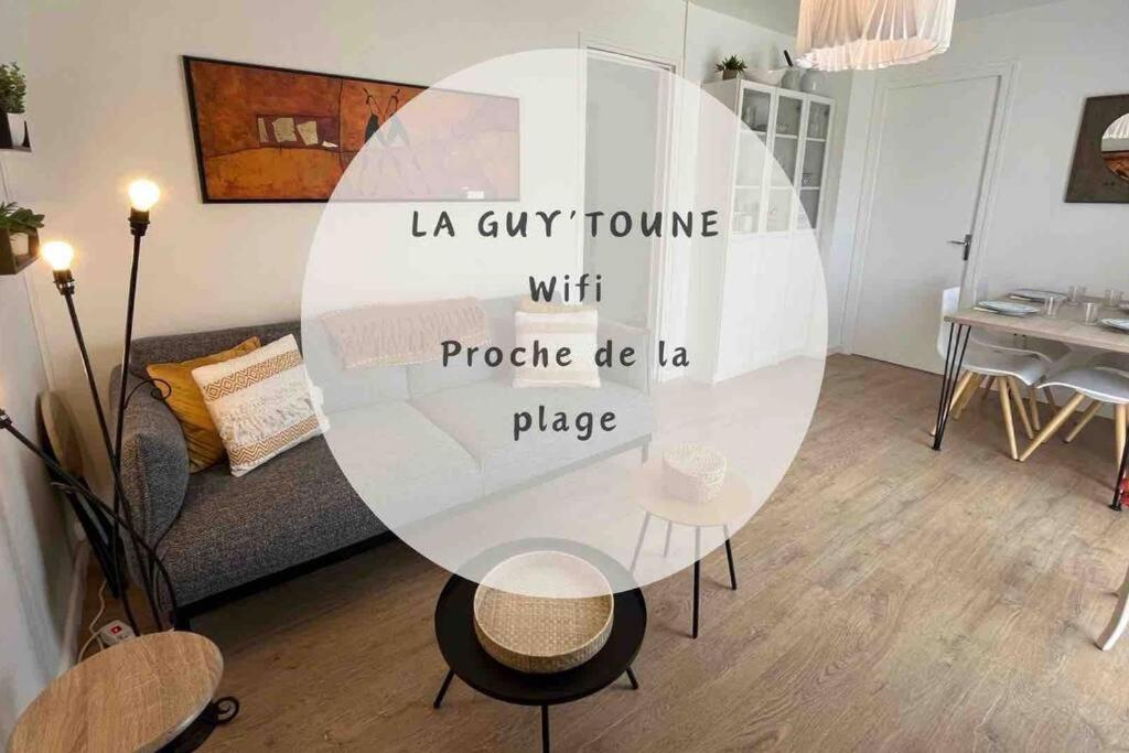 een woonkamer met een tafel in het midden van een kamer bij La Guy’toune in Varaville