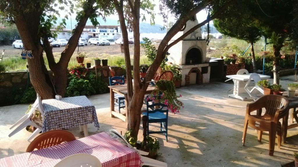 a patio with tables and chairs under a tree at Deniz Yıldızı Pansiyon in Marmaris