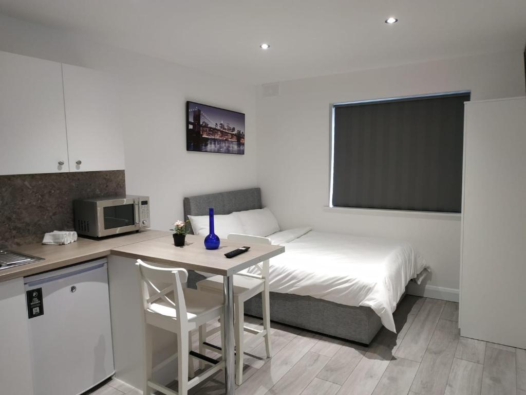 Habitación pequeña con cama, mesa y cocina en Oceanik, en Dublín