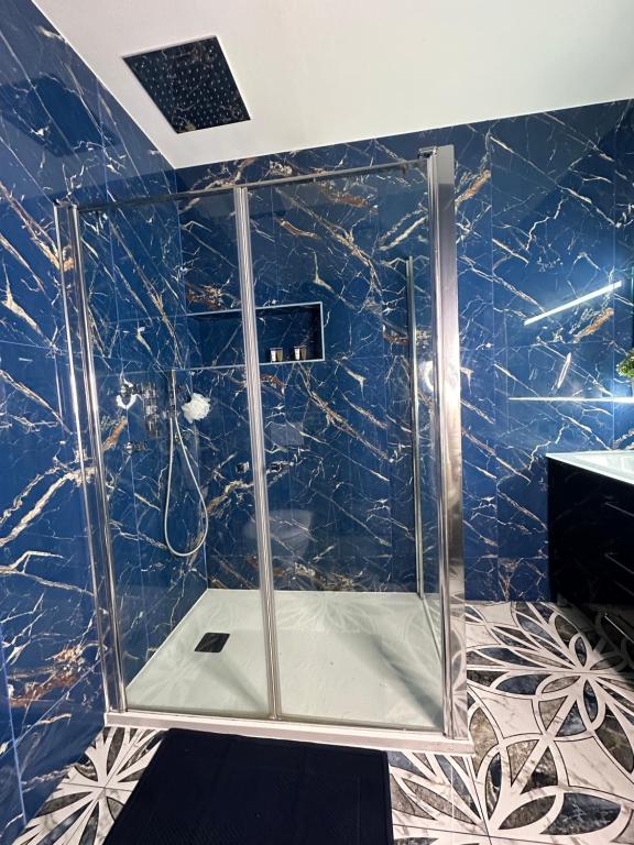 een badkamer met een douche en blauwe marmeren muren bij Chambre cozy proche Paris/CDG in Le Blanc-Mesnil
