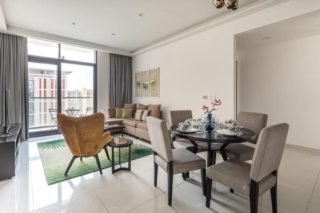 - un salon avec une table, des chaises et un canapé dans l'établissement Frank Porter - Damac Celestia, à Dubaï