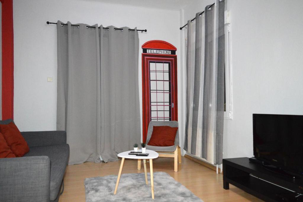 a living room with a phone booth and a couch at Ευρύχωρο διαμέρισμα στο κέντρο της πόλης in Kastoria