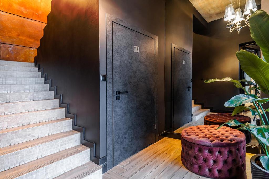 un pasillo con escaleras y un taburete púrpura en NeroHome Bed&Breakfast en Łomża